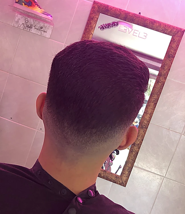 Fade bajo en la nuca, visto de espaldas frente al espejo